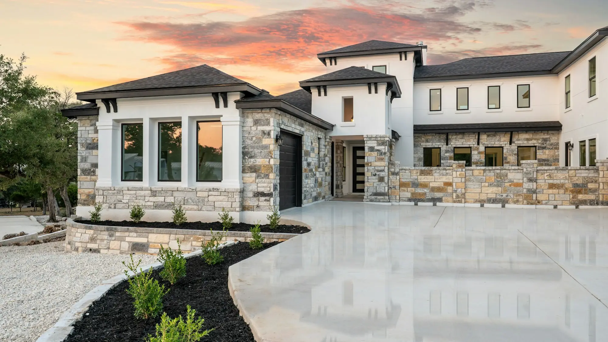 Modern custom home with stone accents at sunset (placeholder photo)